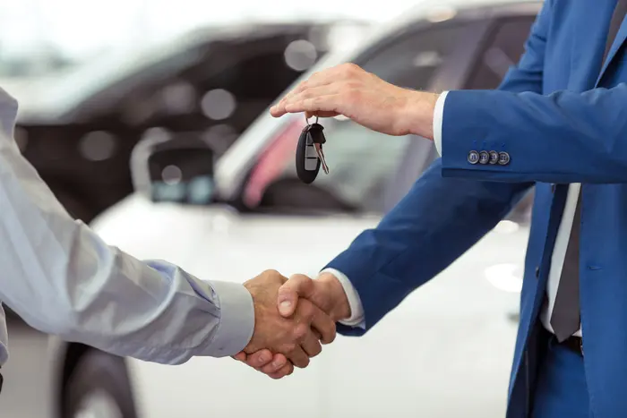 car buyer inspecting a vehicle inside a dealership showroom