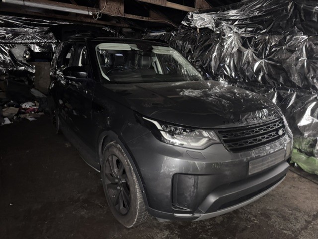 police officers examining vehicles at a chop shop in Romford