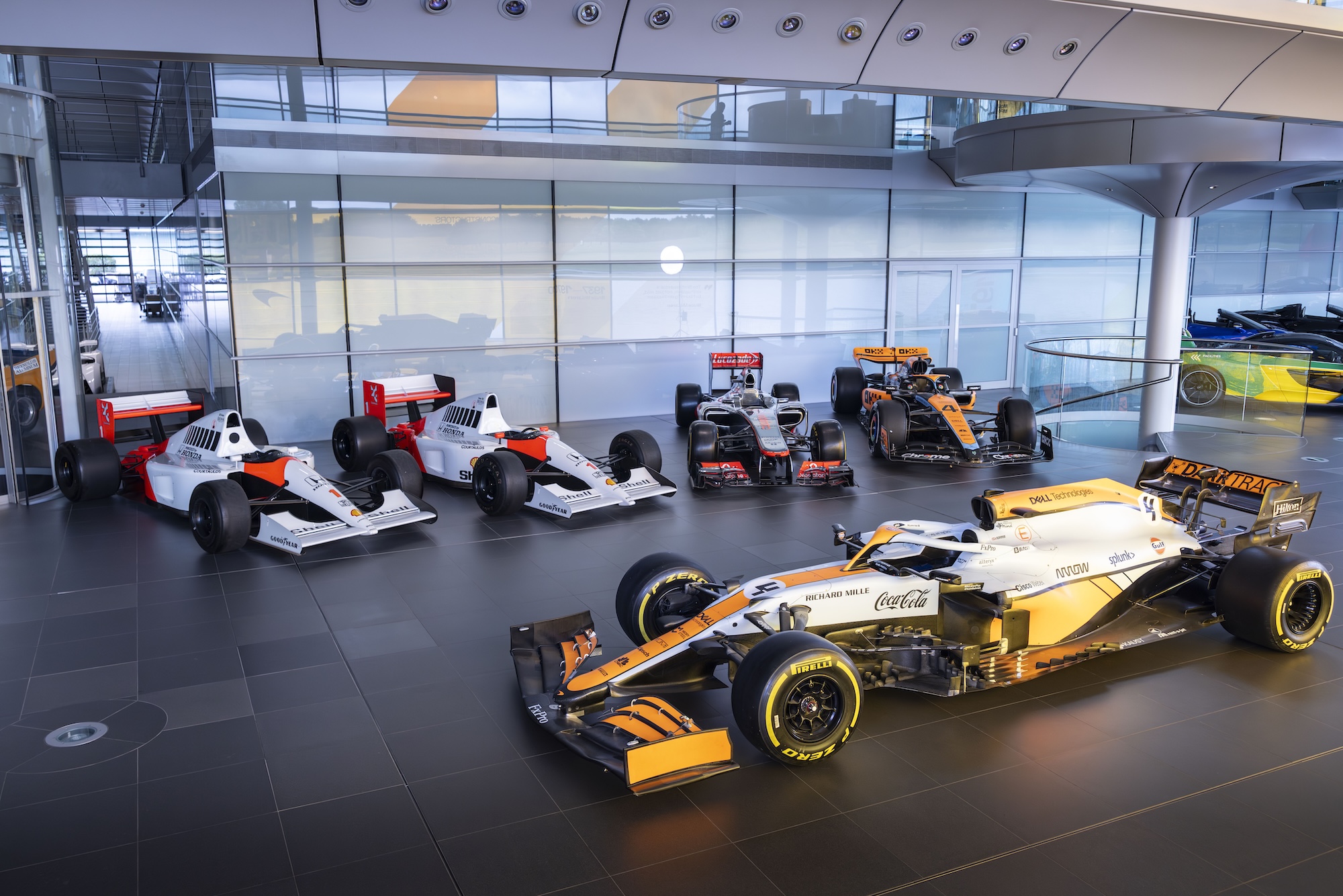 Tom Hartley Jnr standing beside a McLaren Formula One car